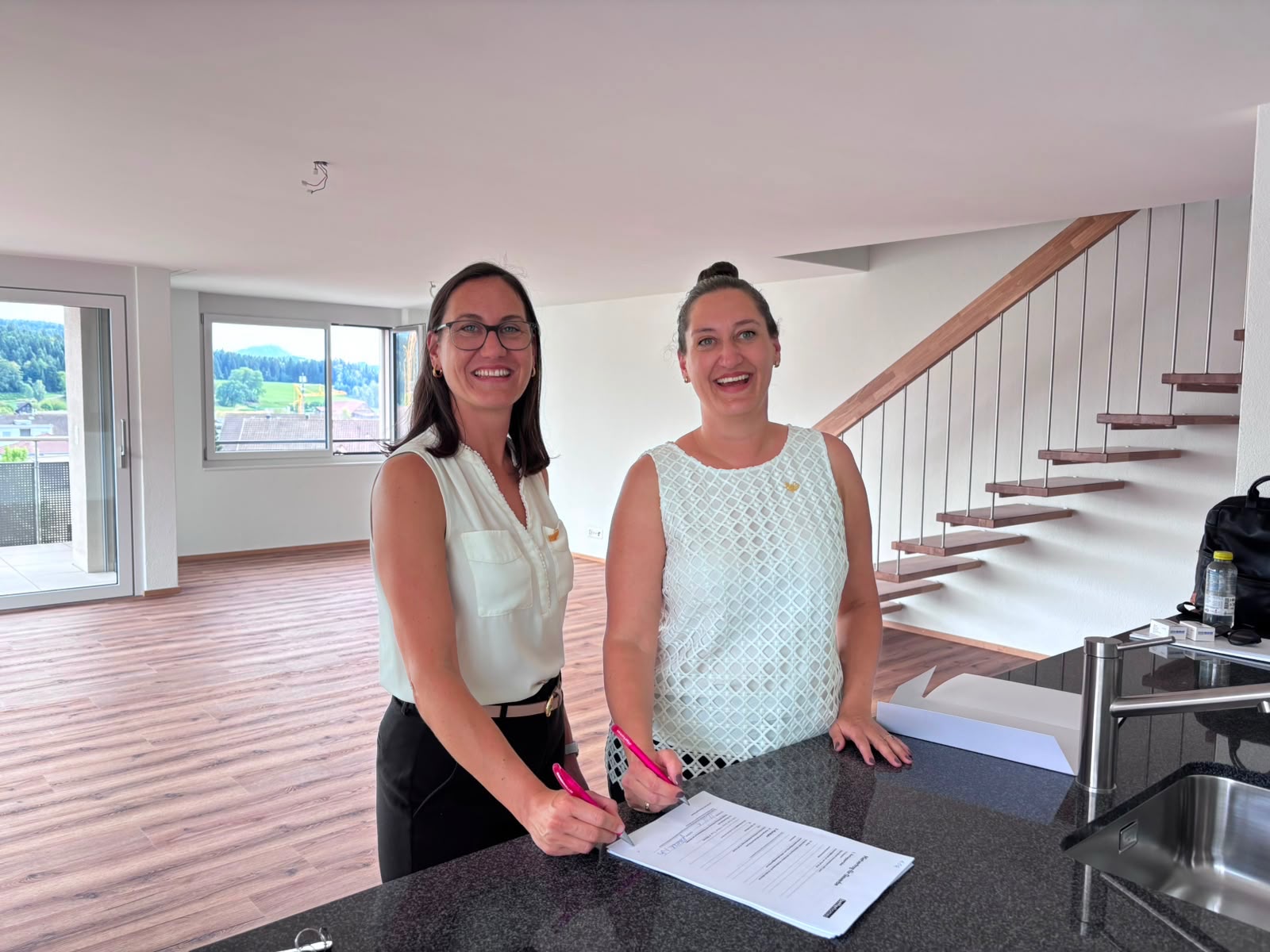 Sibille und Marianne unterzeichnen die Mietverträge für die Wohnungen in Ruswil