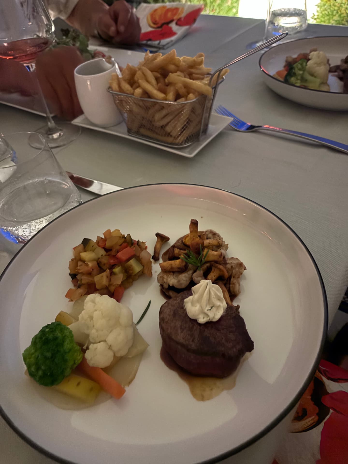 Gedeckter Tisch mit Steak, Pfifferlingen und Roséwein im Restaurant Pony